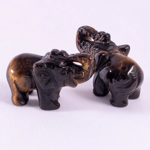 Macro shot of 1.5 inch tiger eye stone elephant statues with polished carved textures