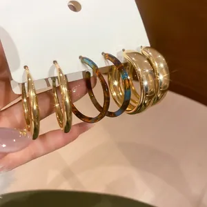 Three pairs of C-shaped hoop earrings in gold metal and tortoiseshell resin finish