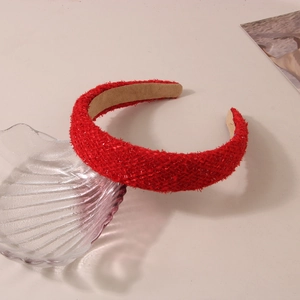 Close-up of red plaid woven headband on a decorative shell tray with soft lighting