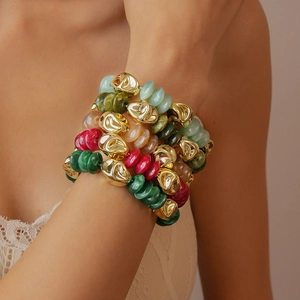Close-up of colorful acrylic beaded multi-layer bracelet with irregular gold metal beads