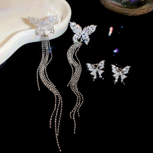 Detailed view of silver butterfly tassel earrings with sparkling cubic zirconia on black background
