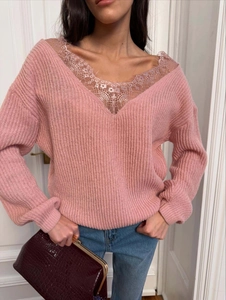 Detail of pink knit top featuring deep V-neckline with delicate floral lace patchwork trim