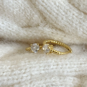 Elegant gold double stone ring with rope texture band on a white knit background