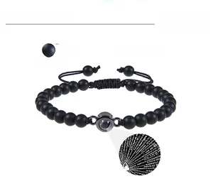 Detail of 6mm black matte bead bracelet with I Love You projection stone and woven rope
