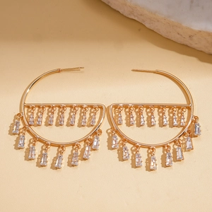 Detail of gold geometric earrings with hanging rectangular cubic zirconia tassels