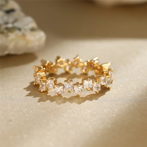 Detailed close-up of a gold plated ring with a continuous row of square-cut cubic zirconia