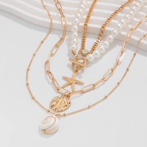 Close-up of layered gold ocean necklace with starfish, shell charms and pearls