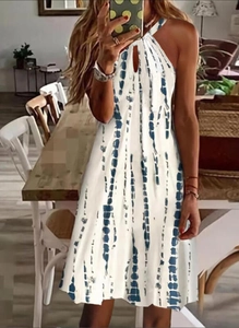 Détail de l'encolure dos nu et des rayures tie-dye bleues sur robe d'été blanche