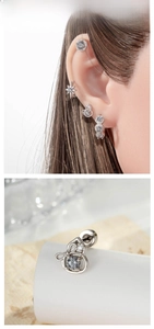Detailed view of silver star zircon cartilage studs and hoop earrings set on model ear