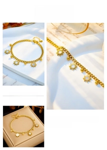 Detail of gold Cuban chain bracelet with sunflower pendants and mother of pearl inlay