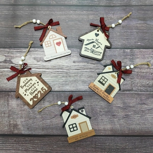 Wooden house Christmas ornaments with 2025 New Home text and plaid bows on wood background