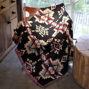 Close-up of bohemian tribal jacquard blanket featuring colorful fringes on an armchair