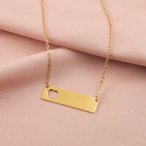 Detailed view of golden pendant necklace with hollow heart on pink silk background