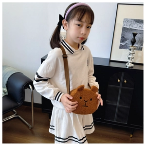 Close-up of a child wearing a cute brown plush bear crossbody bag with shoulder strap
