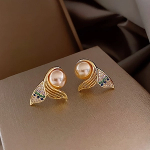 Macro shot of gold fishtail earrings with champagne pearl and colorful cubic zirconia