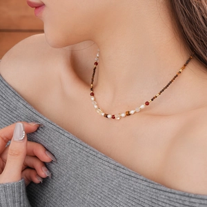 Detail of beaded necklace with freshwater pearls, tiger eye stones, and gold accents