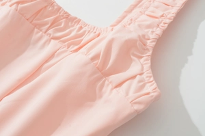 Detail of pink French dress neckline with delicate straps and smooth fabric texture