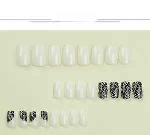 Dettaglio di unghie finte quadrate zebrate con linea argento e finitura bianca