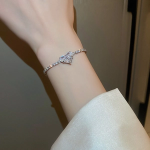 Macro detail of silver zircon heart bracelet with pear-cut crystals on a model's wrist