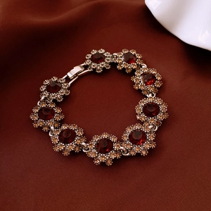 Detail view of retro silver bracelet with red crystal floral units on dark fabric