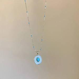 Collier doré élégant avec pendentif turquoise ovale et petites perles bleues