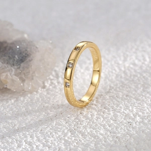 Minimalist 18K gold plated ring with three square-cut zircon stones on a white textured base