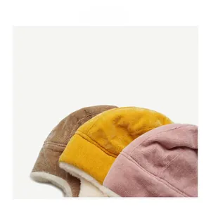 Detail of warm winter corduroy trapper hats in brown, yellow, and pink with plush lining