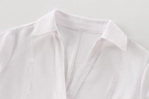 Detailed view of the V-neck lapel and breathable linen blend fabric on white shirt