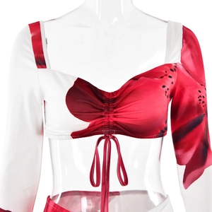Detail of sexy asymmetric printed bikini top with red patterned and white long sleeves