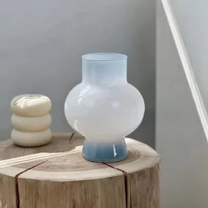 Detail of frosted gradient glass vase with blue and white tones on a wooden base