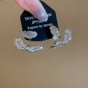 Macro view of silver leaf studs with cubic zirconia on a black display card