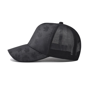 Detail of black trucker hat featuring maple leaf pattern and breathable mesh back