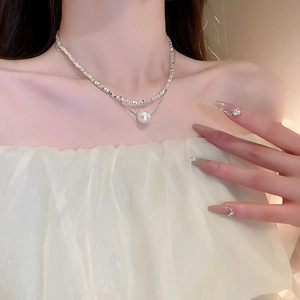Double layer necklace with silver textured chain and white pearl on a model
