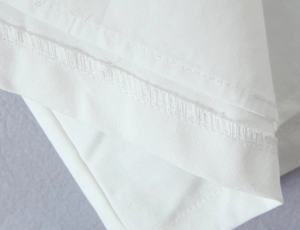 Detailed close-up showing the precise stitching and hem of the white sailor dress fabric
