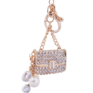 Mini handbag keychain with golden metal base, sparkling rhinestones and pearl pendant