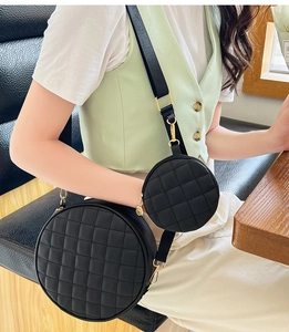 Detail of round quilted shoulder bag with wide strap and attached small coin purse