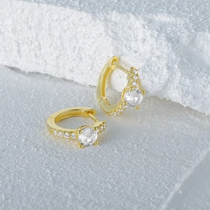 Macro shot of gold S925 sterling silver hoop earring with four-prong set sparkling zircon