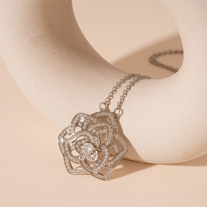 Macro shot of rose-shaped pendant with pavé zircon settings and a center crystal stone
