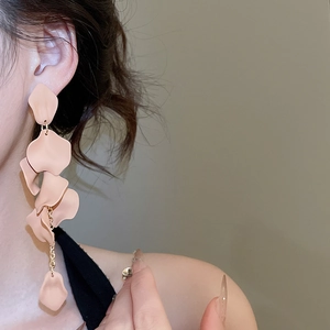 Detailed view of long peach petal tassel earrings on model showing elegant drape