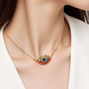 Close-up of a gold Evil Eye pendant necklace with colorful enamel and pavé zircons