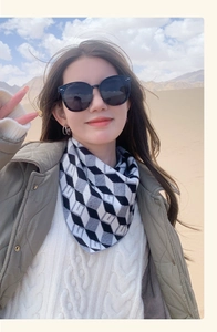 Detailed close-up of monochrome geometric knit scarf featuring 3D cube patterns in the desert
