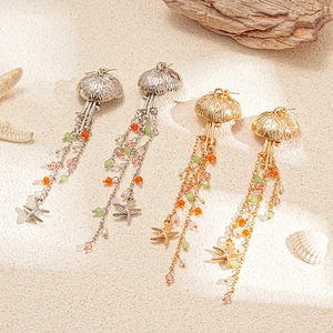 Sea-style jellyfish and starfish drop earrings with glass beads on a beach background