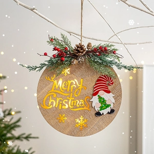 Wooden Merry Christmas gnome sign with pine needles and berries hanging on a winter tree
