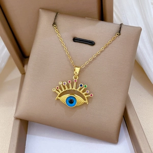 Detail of gold evil eye necklace with colorful zircons in a brown velvet jewelry box