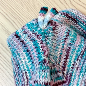 Macro shot of multi-color knitted beanie with soft wool texture and mixed yarn details