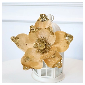 Close-up of champagne gold glitter poinsettia flower on a white hollow lantern base