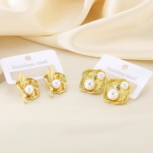Boucles d'oreilles fleurs en acier doré 18k avec perles sur fond de soie