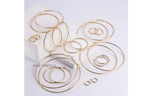 Detailed set of varied size gold titanium steel hoop earrings on minimalist display