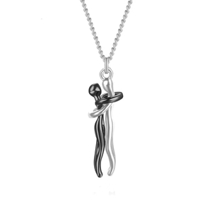 Detail shot of black and silver hugging couple pendant necklaces with fine metal chain