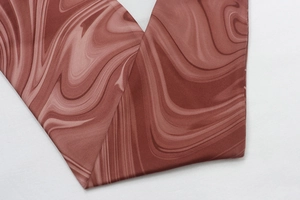 Gros plan du tissu à motif marbré avec texture ondulée bordeaux et crème élégante
